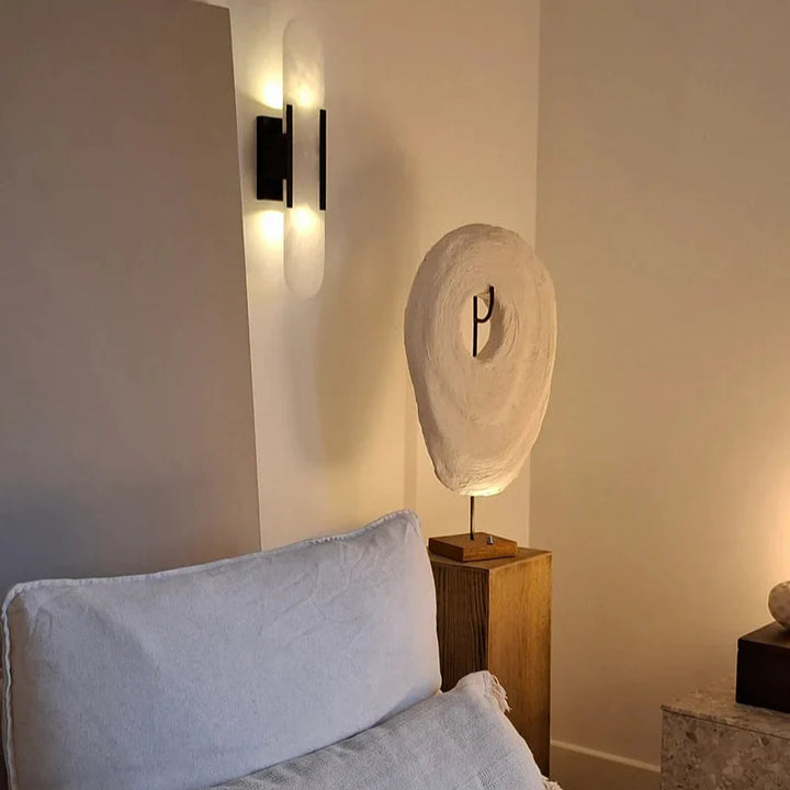 "Modern black and gold LED wall lamp with oval Lucite crystal centerpiece, ideal for dining room lighting."