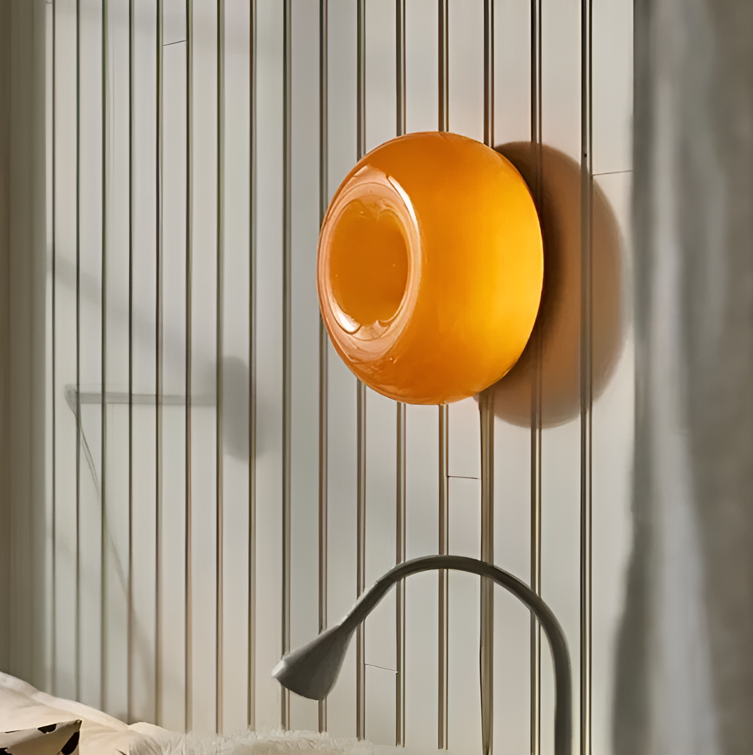 Orange donut-shaped LED lamp with warm glow, fits as a wall or table lamp, whimsical design with high-quality glass and metal