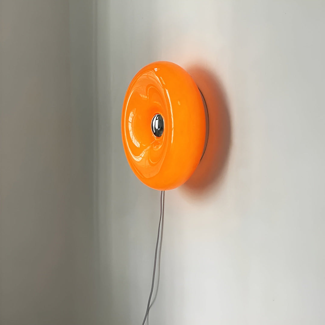 Orange donut-shaped LED lamp with warm glow, fits as a wall or table lamp, whimsical design with high-quality glass and metal