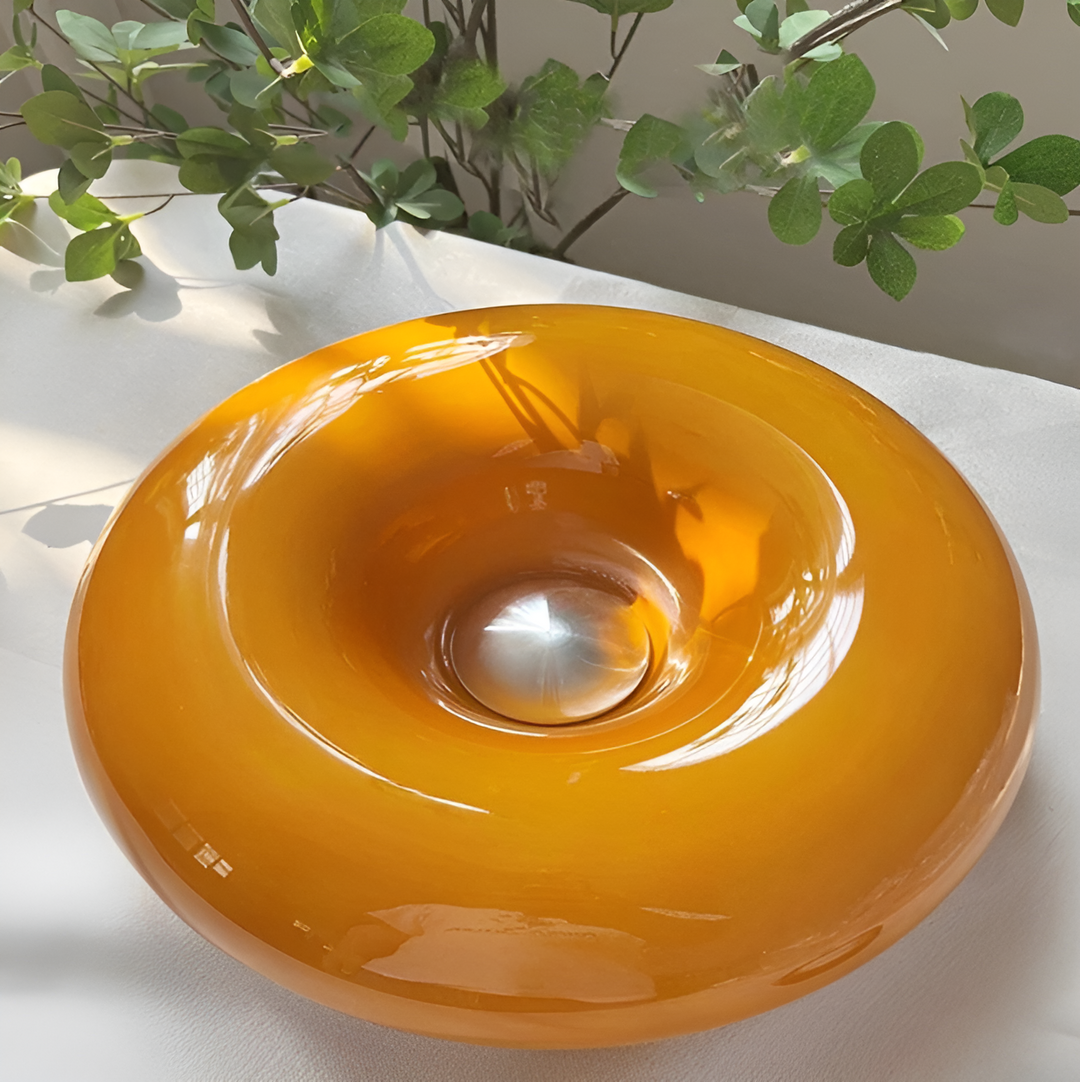 Orange donut-shaped LED lamp with warm glow, fits as a wall or table lamp, whimsical design with high-quality glass and metal