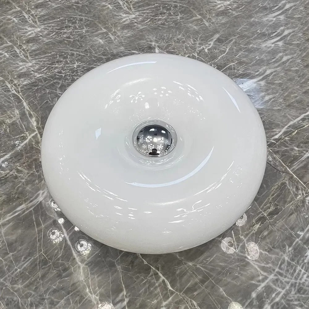 Orange donut-shaped LED lamp with warm glow, fits as a wall or table lamp, whimsical design with high-quality glass and metal