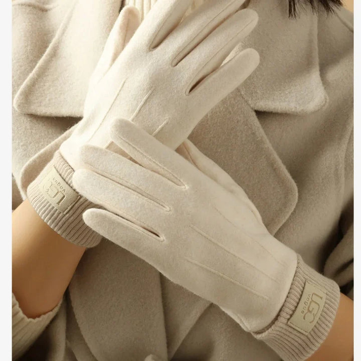 Close-up of the thumb and index finger of a cashmere touchscreen glove, showing conductive material.