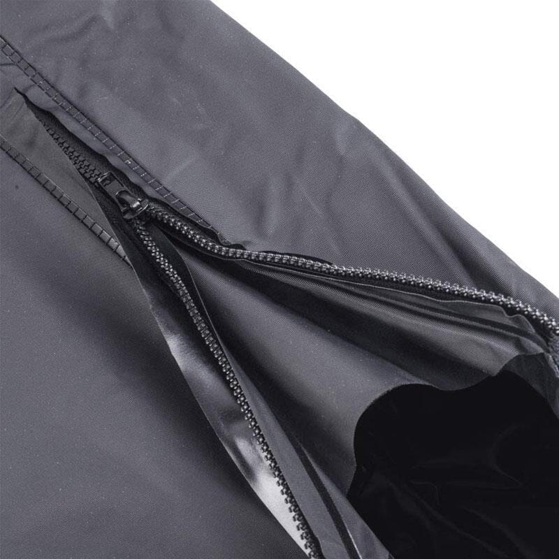 Person wearing black waterproof boot covers over shoes, walking through a wet outdoor environment