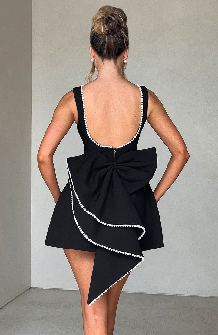 Back view of a white structured mini dress, emphasizing the sophisticated cut and structured silhouette.