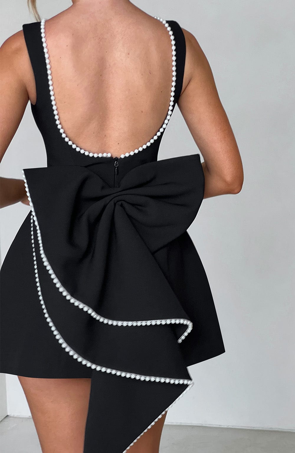 Detailed shot of the structured elements on a pink mini dress, suitable for wedding guests.