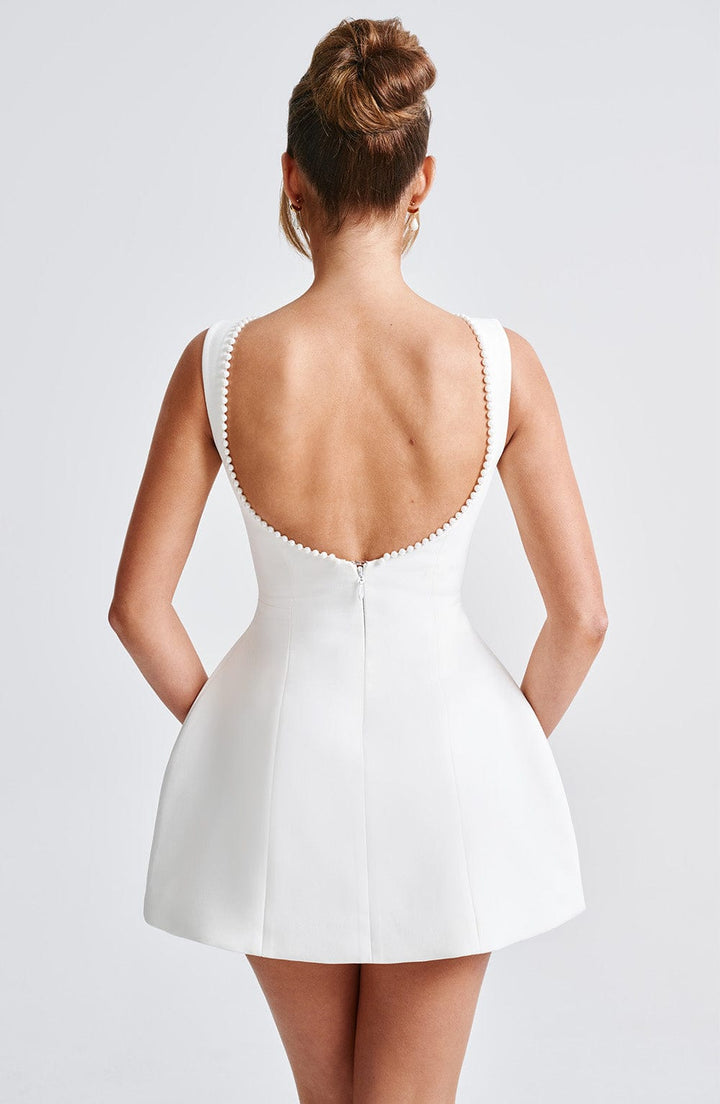 A collection of pink, black, and white structured mini dresses, versatile for various special occasions.
