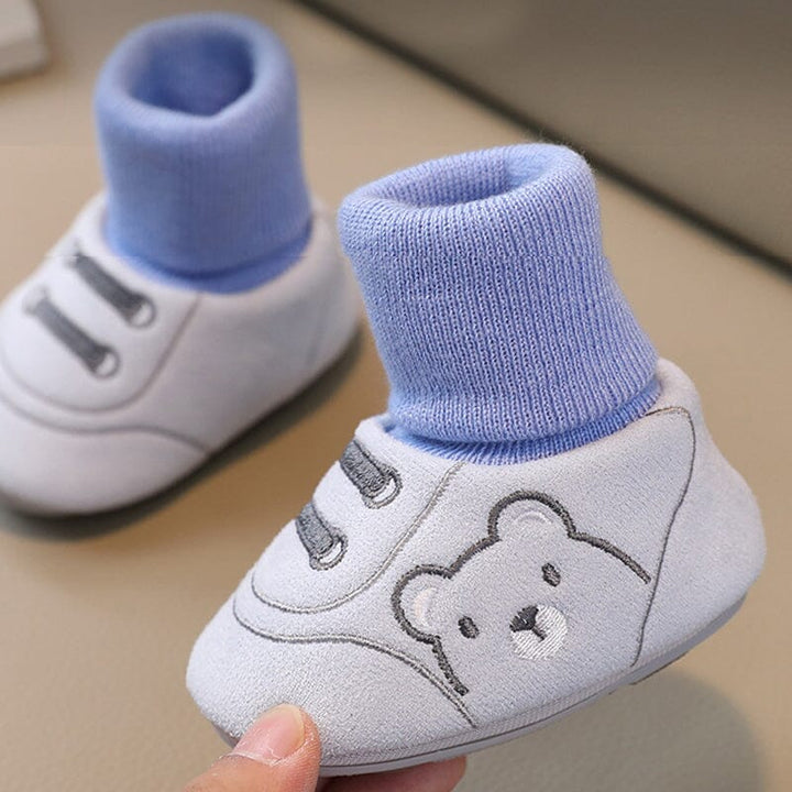 Overhead view of a pair of colorful plush baby booties, warm winter shoes