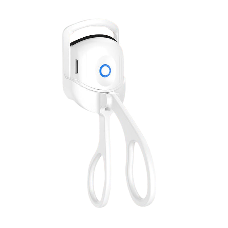 Heated eyelash curler in hand, emphasizing its lightweight and portable nature as a beauty tool
