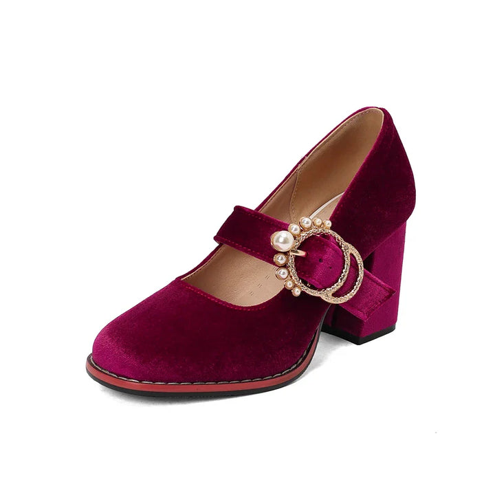 Model wearing red velvet pearl embellished block heels, demonstrating their stylish look.