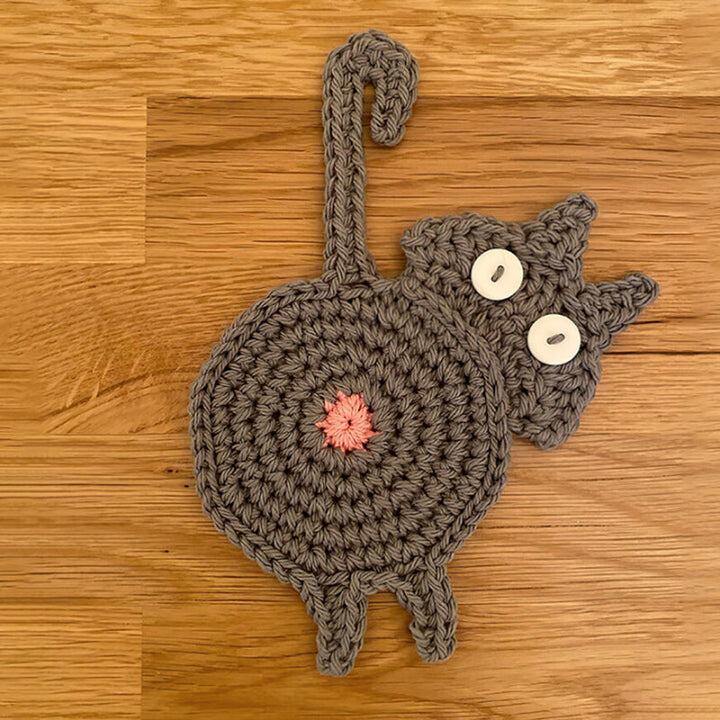 Single cat butt coaster on a coffee table, showcasing its funny and unique design for drinkware.