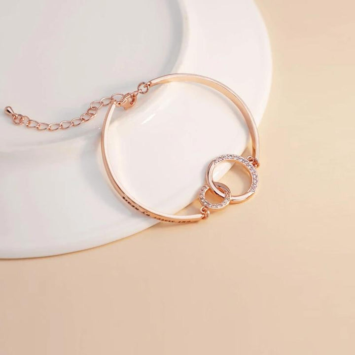 Close-up of a silver friendship bracelet with a delicate heart charm, ideal adjustable women's jewelry.