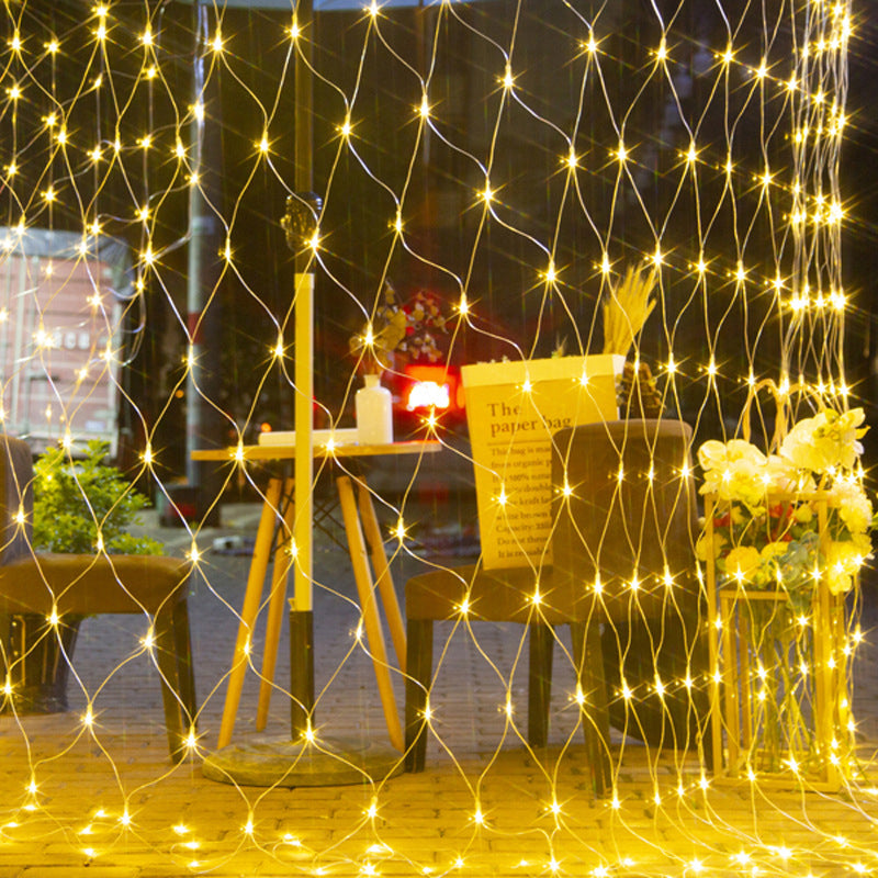 Solar powered LED mesh lights illuminating a backyard fence, perfect for evening gatherings