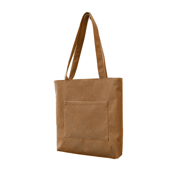 Texture focus on the corduroy material of a women's casual shoulder bag, showcasing its unique ridged surface.