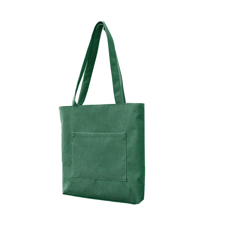 Flat lay of a women's corduroy casual tote bag, displaying its functionality and appeal as a fashion accessory.