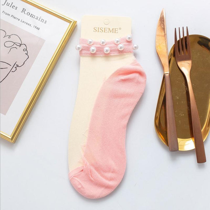 Women's ankle socks combining a playful fishnet with sophisticated pearl embellishments.