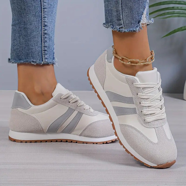 Stylish women's retro lace-up sneakers. Comfortable low-top casual footwear with vintage striped design.