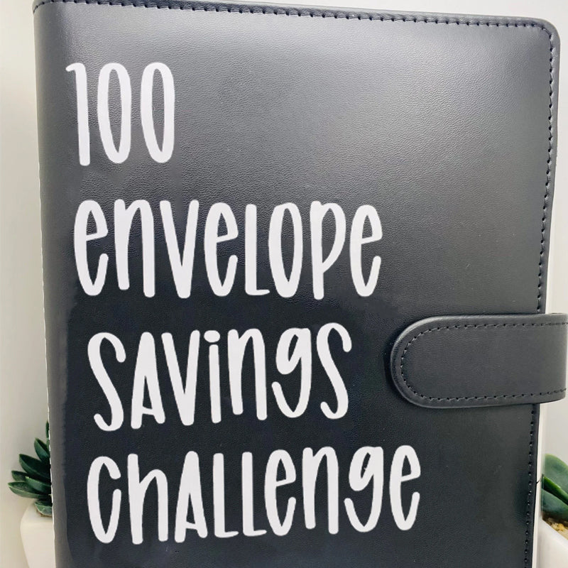 100 Envelope Savings Challenge Binder on a desk with a pen, emphasizing its use as a finance binder