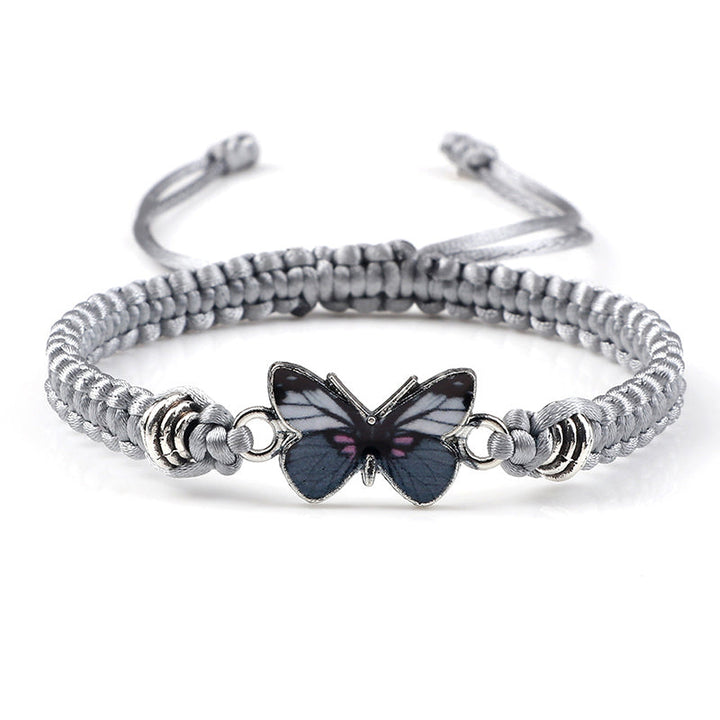 Lifestyle shot of someone wearing the black adjustable woven butterfly charm bracelet.