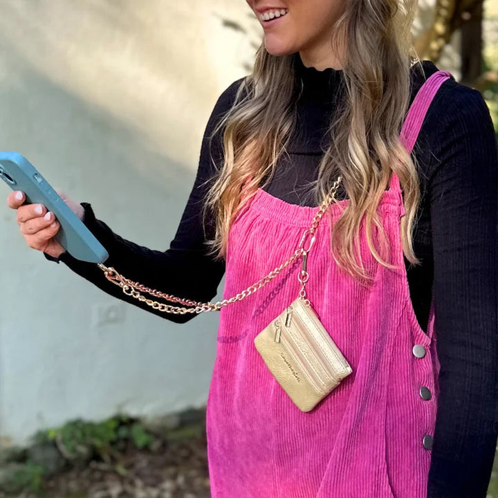Lifestyle shot: person using a phone lanyard with pouch while on the go, emphasizing active lifestyle.