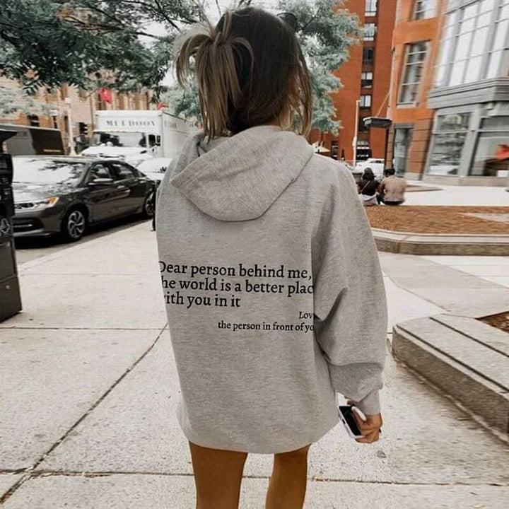 Couple laughing, both wearing 'Dear Person Behind Me' matching sweatshirts, gift idea