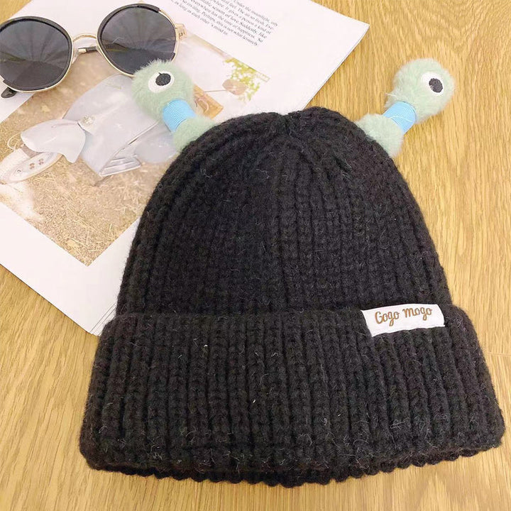 Person smiling while wearing a blue Fun Monster Knit Beanie