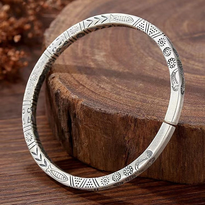 Close-up of unisex copper totem bangle bracelet, intricate ethnic design, adjustable fit