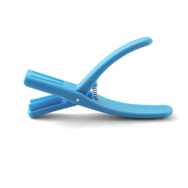 Hand holding a red plastic Seafood Sheller Tool, demonstrating its comfortable grip