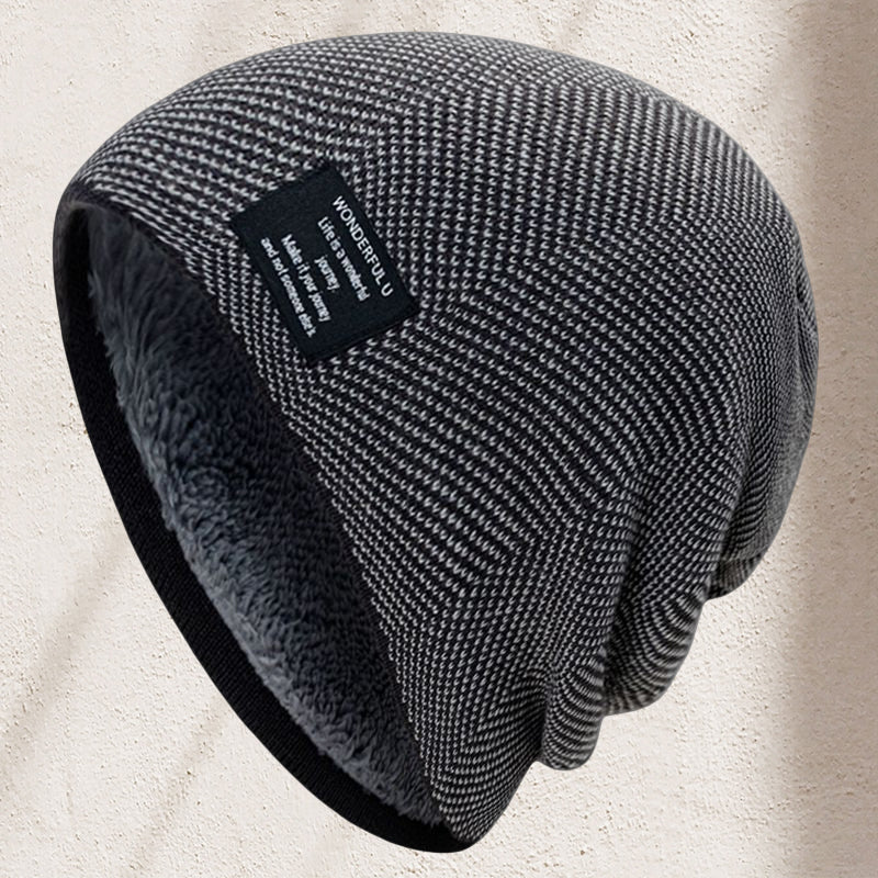 A stack of assorted color unisex thermal knit beanie hats for winter. Black, grey, navy, red, green.