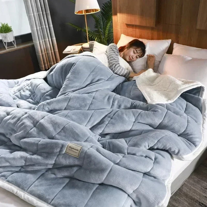 Warm flannel coral fleece throw blanket draped over a sofa, adding cozy comfort & winter style to living room.