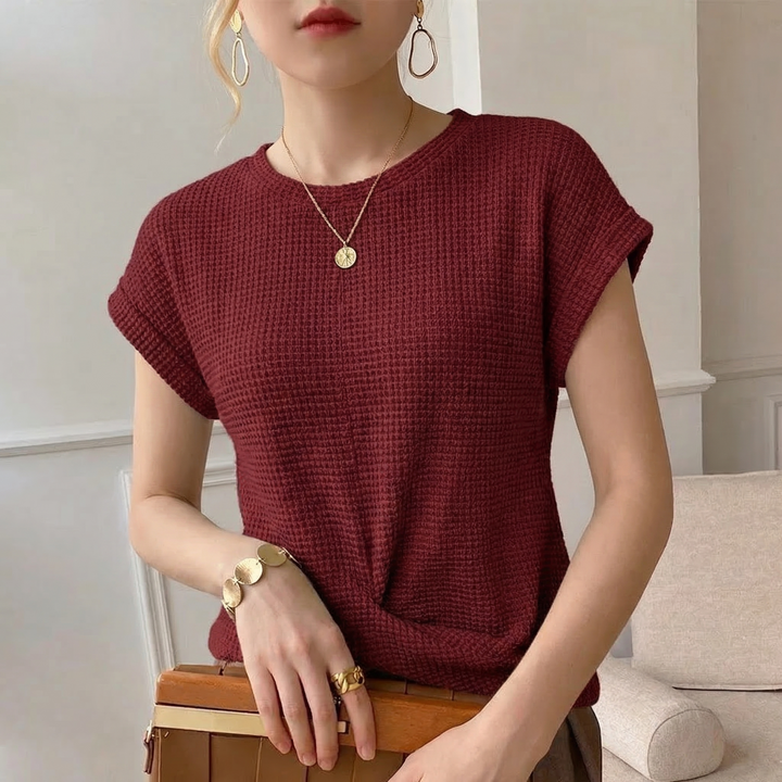 Detailed view of the amber textured fabric and stylish twist front on a women's long sleeve fashion top.