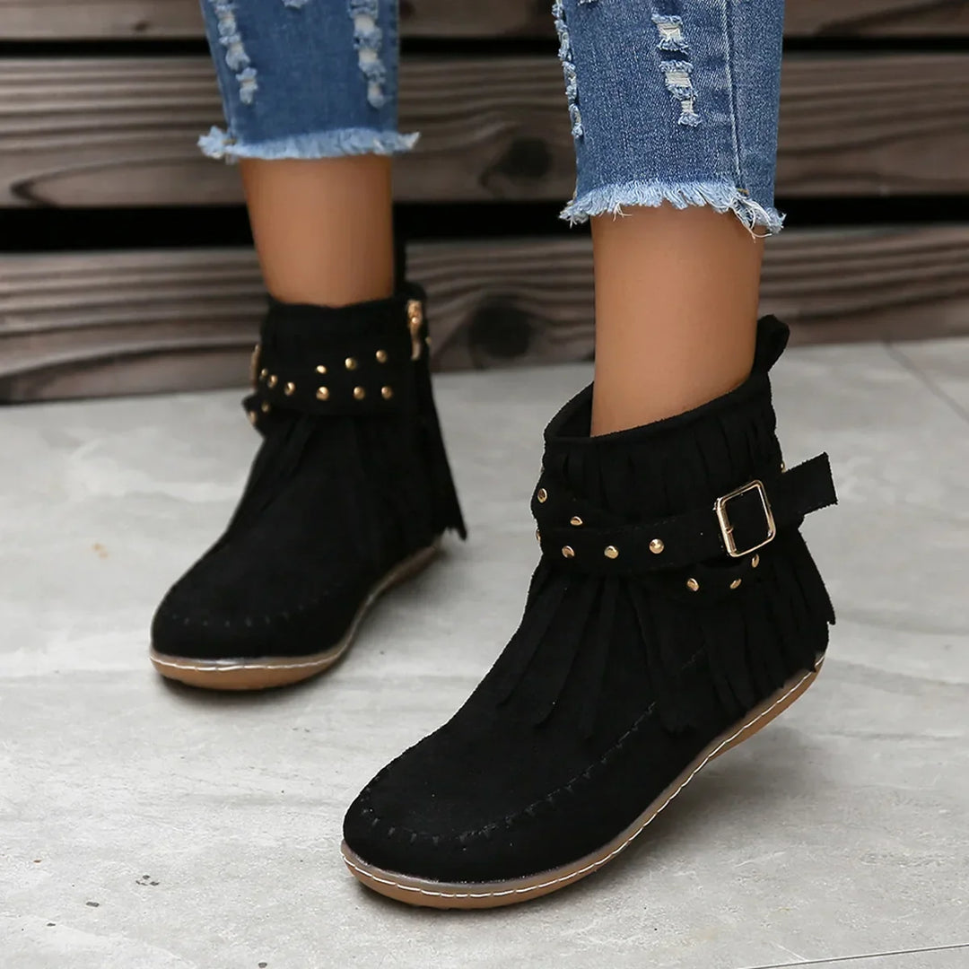 Women's black ankle boots with playful fringe and edgy studded buckle design
