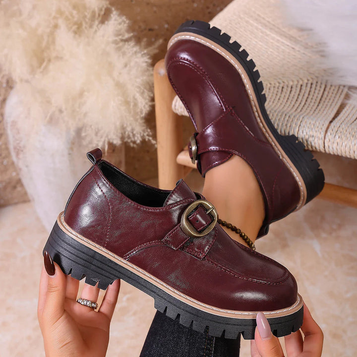 Pair of women's flat leather loafers with decorative buckle, suitable for everyday comfort.