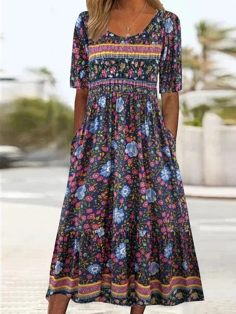 Women's summer boho midi dress. Floral print, round neck, and short sleeves. Includes practical pockets and gathered waist.