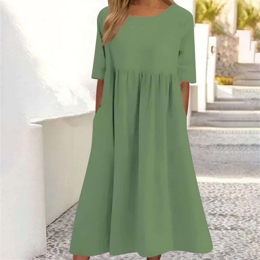 Smocked-waist women's midi dress with breezy fabric, short sleeves, and practical pockets for summer.