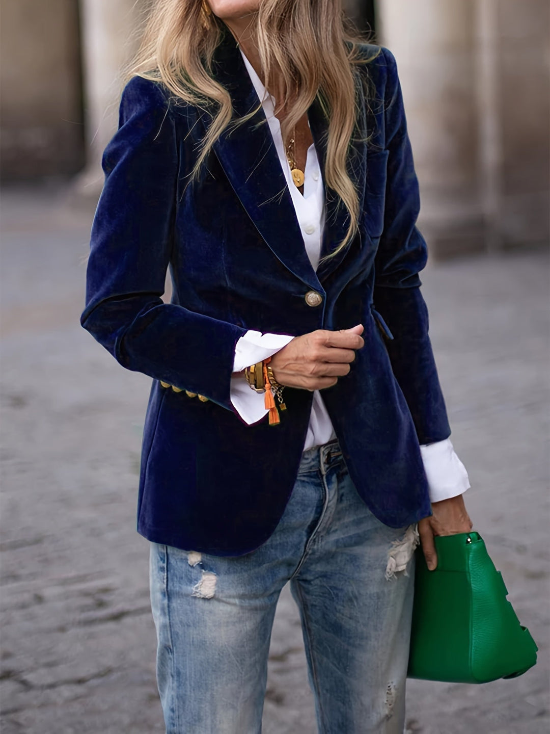 Close-up of a women's classic blazer button detail, showing quality craftsmanship