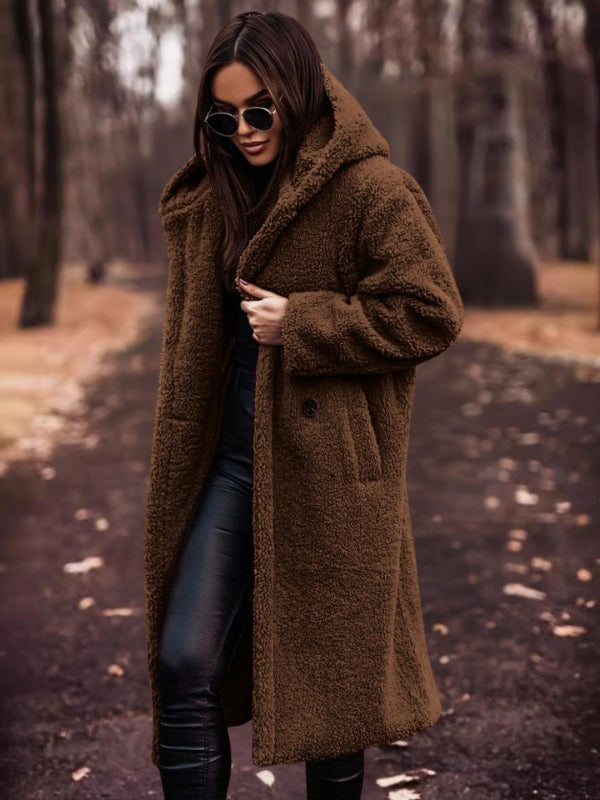 Long women's trench coat with a double-breasted front and belted waist. Chic all-weather outerwear for women.