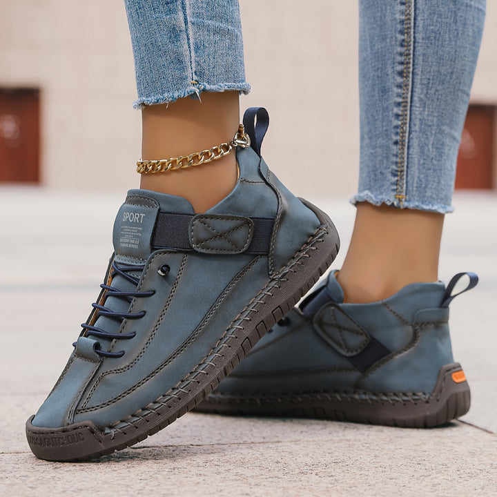 Lightweight women's casual flat lace-up sneakers, highlighting detailed stitching for a unique & comfortable design.