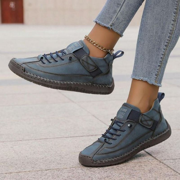 Stylish women's flat lace-up sneakers with stitch detail, offering versatile comfort for any casual or everyday outfit.