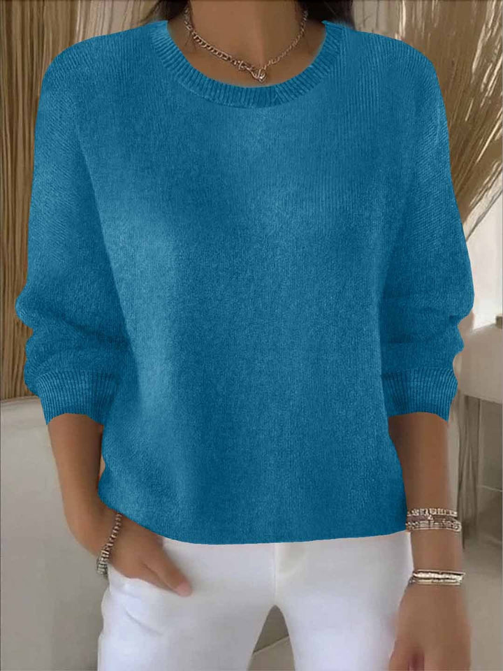 Close-up of the soft knit texture of a women's loose-fit spring pullover sweater, emphasizing comfort