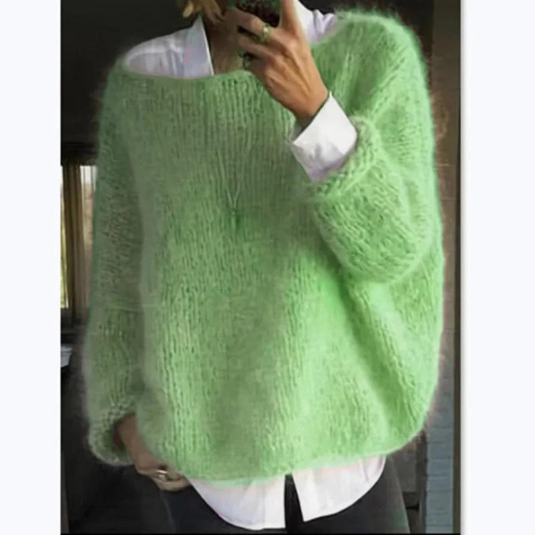 Stack of folded women's knit long sleeve sweaters in various colors, showcasing collection.