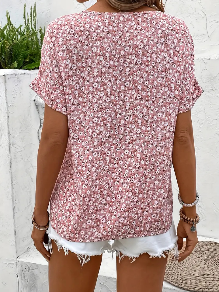 Front view of a women's ditsy floral button-front blouse with short sleeves, showcasing casual summer fashion.