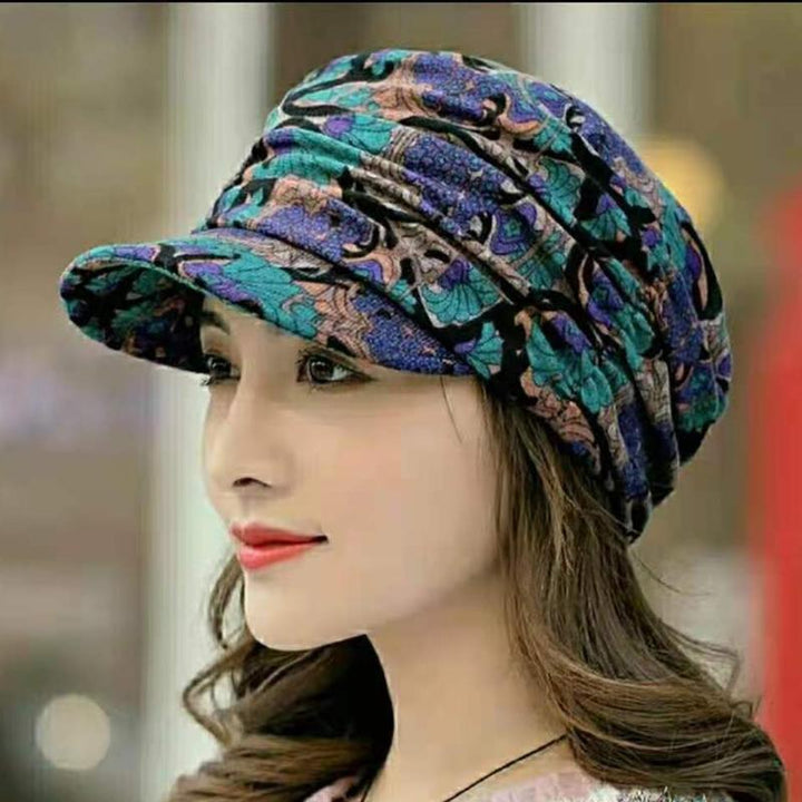 Top view of a women's floral pleated cap, highlighting its structured design and short brim.