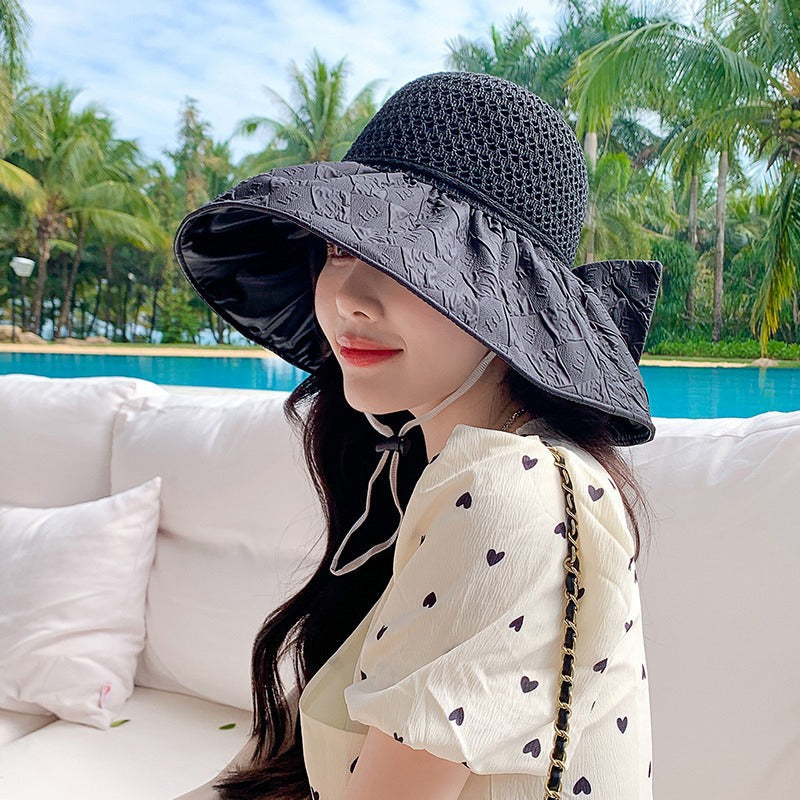 Detail of the bow on a women's foldable wide-brim sun hat, emphasizing its decorative appeal.