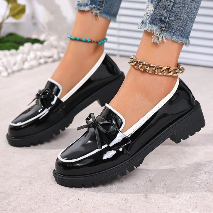 Top-down view of women's glossy loafers, showcasing the full patent leather upper
