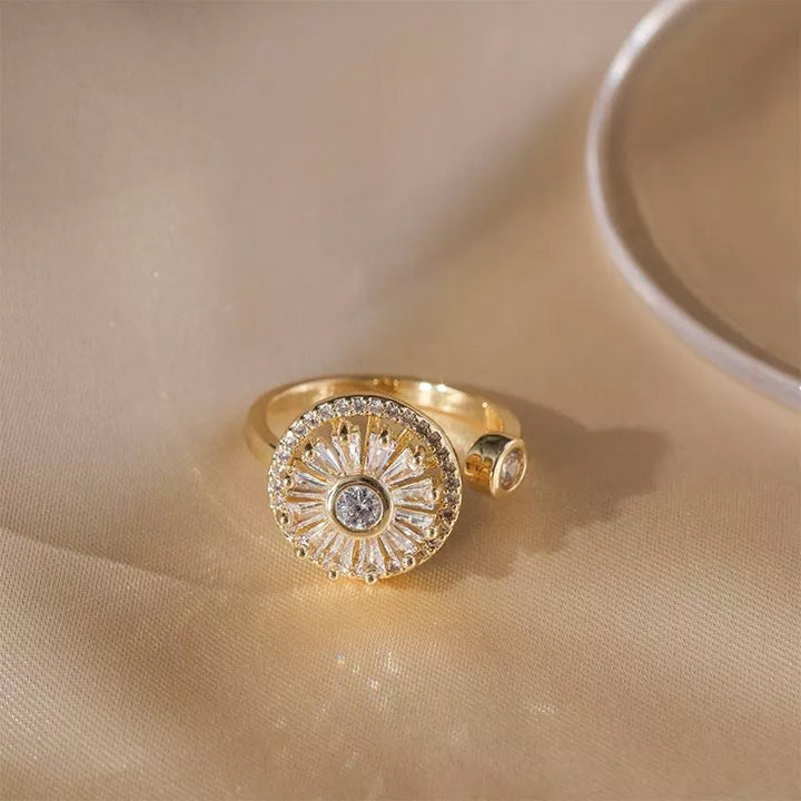 Close-up of a women's gold spinner ring with clear crystals, designed for anxiety relief.