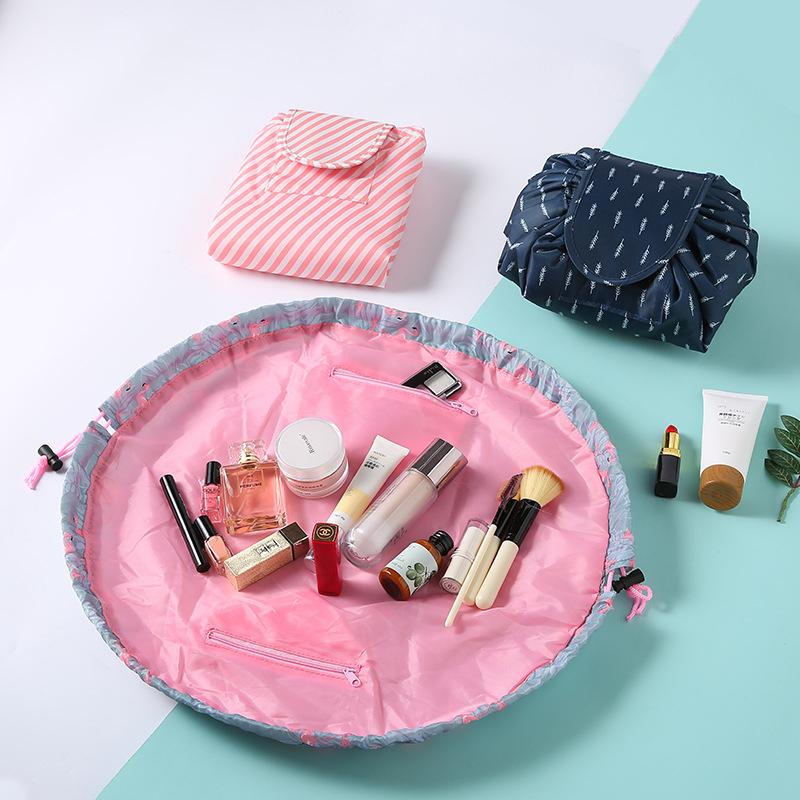 Travel cosmetic bag for women, fully open with drawstring for easy access to beauty accessories, black with white polka dots.