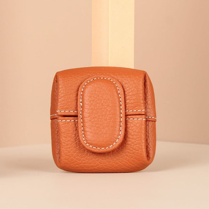 Side profile of a small blue leather coin pouch, emphasizing its slim design