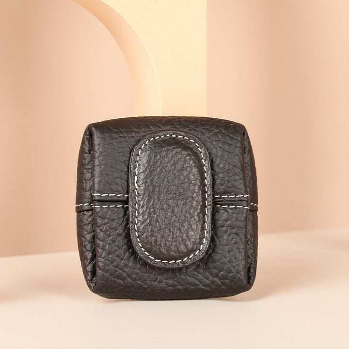 A stack of colorful mini leather coin purses, showcasing different shades