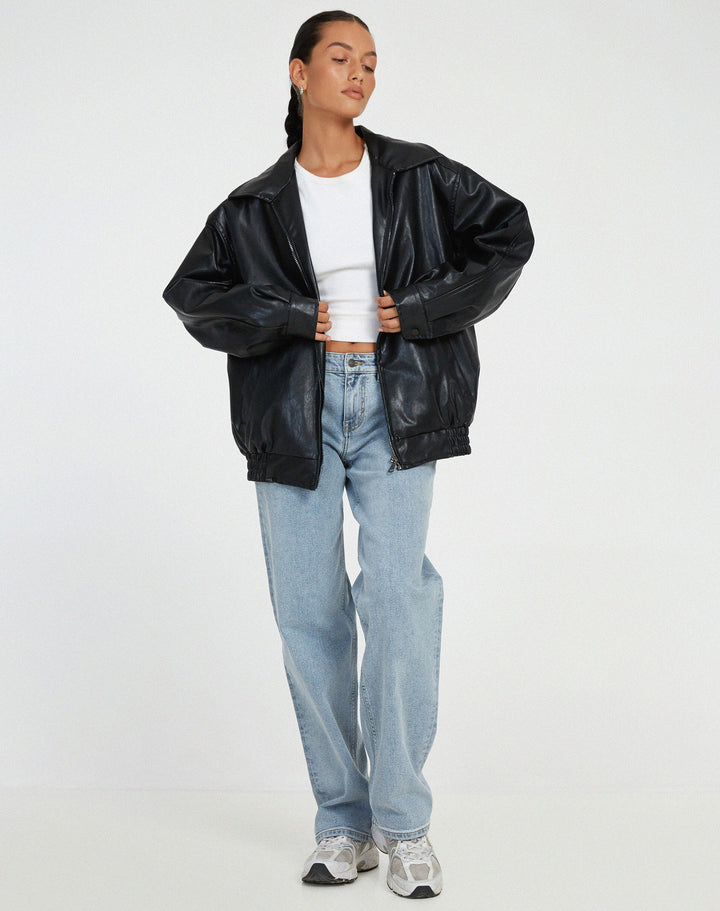 Model wearing a brown oversized faux leather bomber jacket, styled for a casual streetwear look.