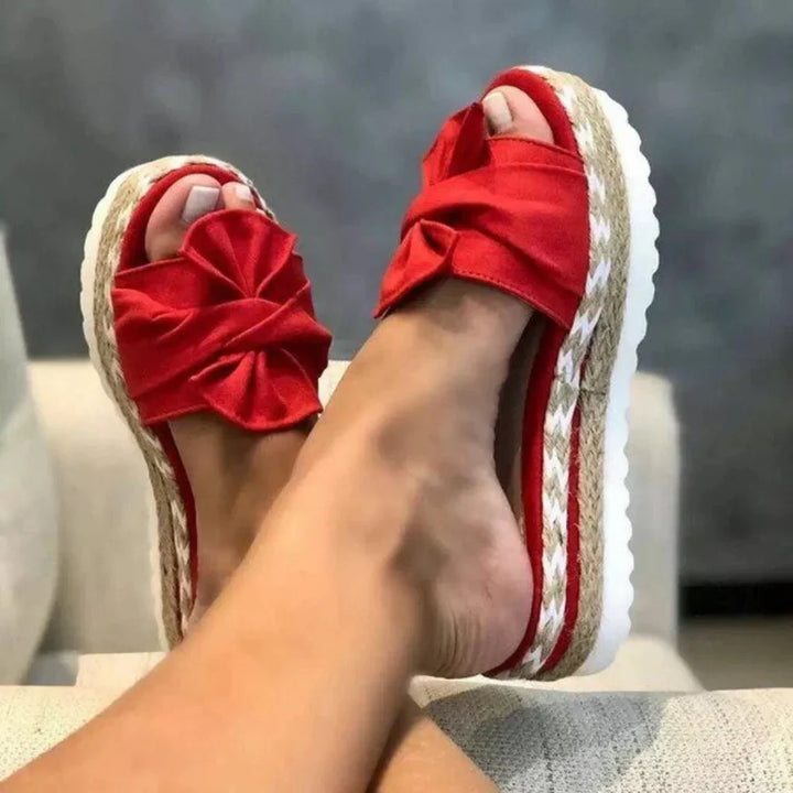 Women's summer footwear: platform bow slide sandals in a trendy design.